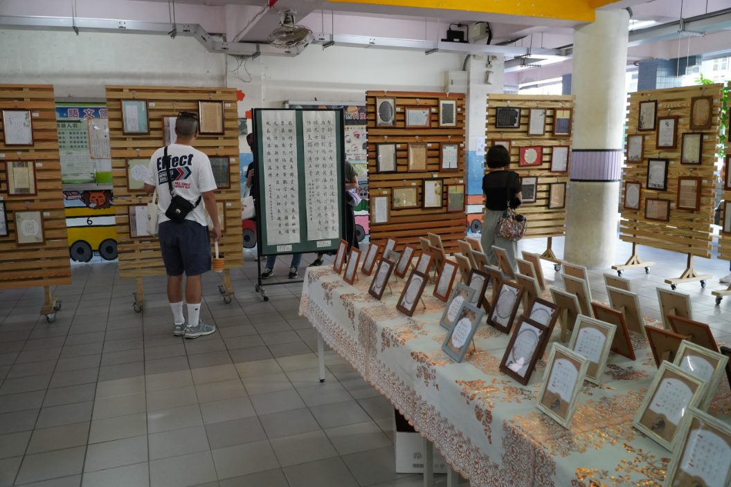 硬筆書法成果展，木質展板上掛滿學生裝裱的書法作品，師生駐足欣賞