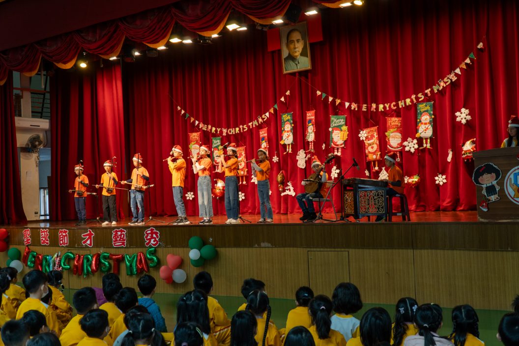 國樂社學生戴著聖誕帽，在舞台上演奏二胡、笛子、琵琶與揚琴